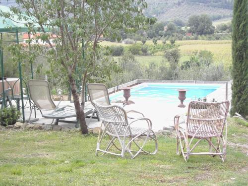 een groep stoelen naast een zwembad bij Belvilla by OYO Tillia in Castiglion Fiorentino