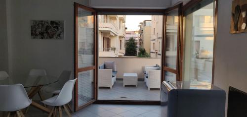 Habitación con vistas a un balcón con mesa y sillas. en Artist Alguerhouse en Alghero