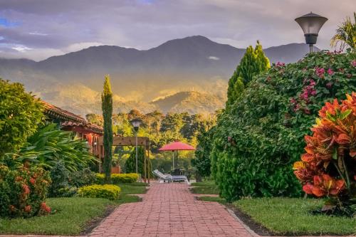 a garden path with a bench and mountains in the background at Hotel Campestre Solar De La Luna in Armenia