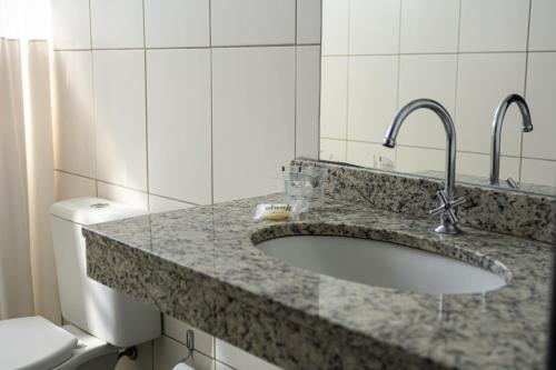 a bathroom with a sink and a toilet at Abudi Hotel in Cuiabá