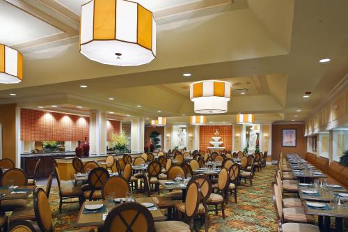 a dining room with tables and chairs and chandeliers at Villa Roma Resort and Conference Center in Callicoon