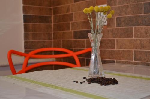 a vase with flowers in it sitting on a table at Соборная Апартаменты in Kamianets-Podilskyi