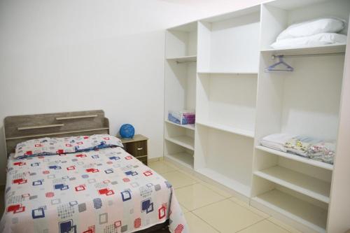 a bedroom with a bed and white shelves at Casa aconchegante a 200m da famosa Praia de Pajuçara in Maceió