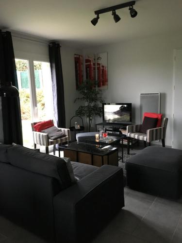 un salon avec des canapés, une table et une télévision dans l'établissement chambres chez Brigitte et Patrick près du Mont st Michel, à Saint-Quentin-sur-le-Homme