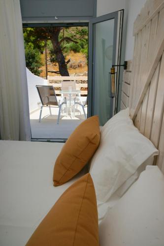 a bedroom with a bed with a view of a patio at Afrodite Luxury Rooms in Telendos