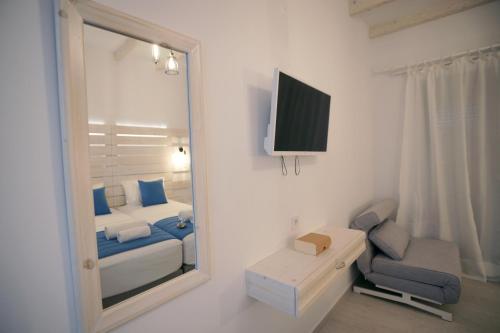 a bedroom with a mirror and a bed and a chair at Afrodite Luxury Rooms in Telendos