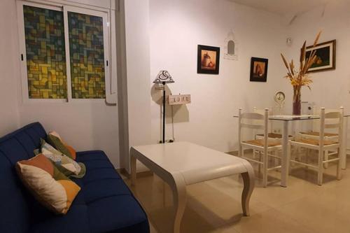 a living room with a blue couch and a table at Sherry house in Jerez de la Frontera