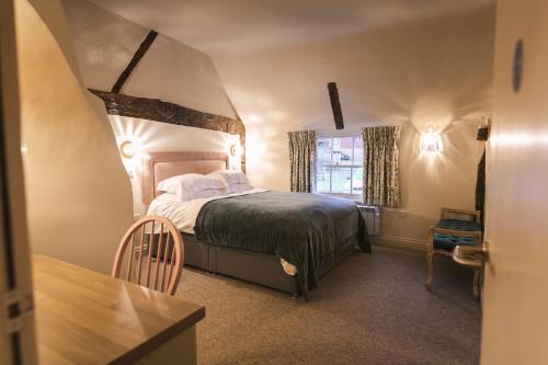 ein Schlafzimmer mit einem großen Bett in einem Zimmer in der Unterkunft The Rose & Crown in Godalming
