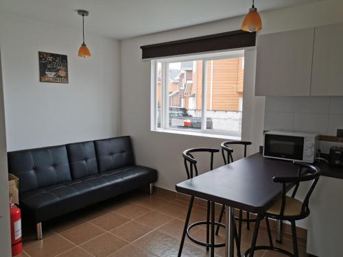 un soggiorno con divano nero e tavolo di Casa Amoblada Puerto Montt a Puerto Montt