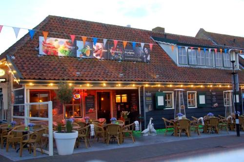 a restaurant with tables and chairs in front of a building at Studio de Pelgrim in Vrouwenpolder