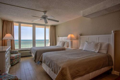 a hotel room with two beds and a large window at 513 - Island Inn in St. Pete Beach