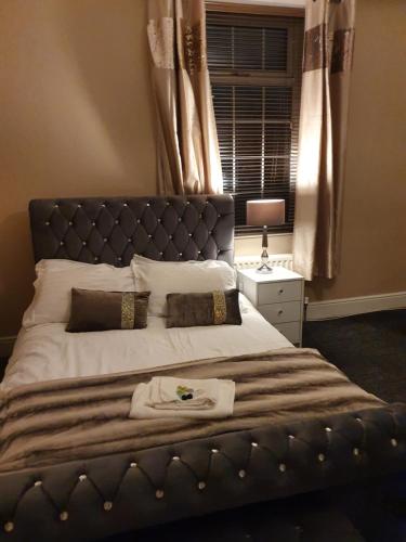 a bedroom with a large bed with a blue headboard at Southfield lodge in Middlesbrough