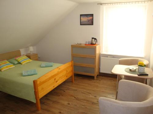 1 dormitorio con 1 cama, mesa y sillas en Lucy, en Władysławowo