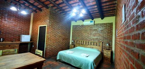 a bedroom with a bed and a brick wall at La Maína Uribe Posada in Uribelarrea