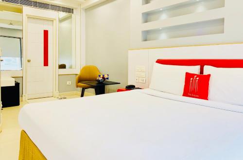 a bedroom with a large white bed with red pillows at City Empire New Delhi Train Station in New Delhi