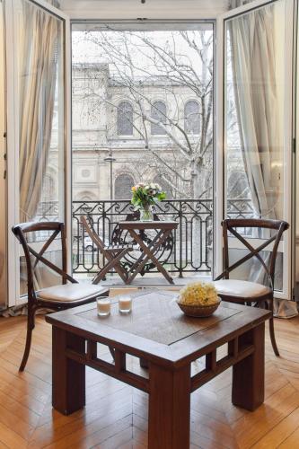 Cette chambre dispose d'un balcon avec une table et des chaises. dans l'établissement Mithouard Apartments, à Paris