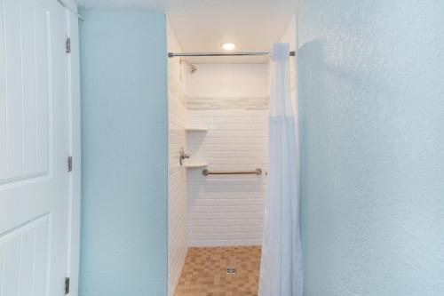 Baño con ducha a ras de suelo junto a una puerta en John Yancey Oceanfront Inn, en Kill Devil Hills