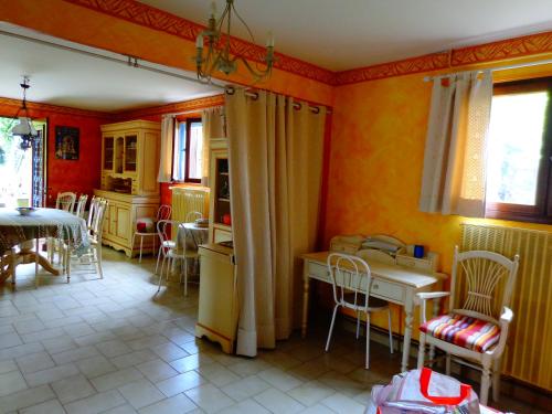 - une cuisine aux murs orange avec une table et des chaises dans l'établissement macaron, à Bagnols-sur-Cèze