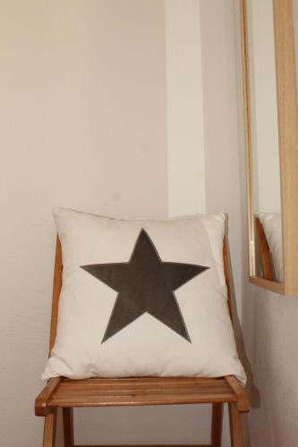 ランポーヤにあるApt ideal para familias cerca del marの木製のベンチの枕の上の黒い星