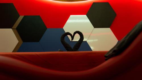 two hearts are sitting in a bed with a table at Hotel Río in Mexico City