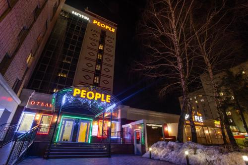 un edificio con un cartel que lee a la gente por la noche en Hotel People, en Cheboksary