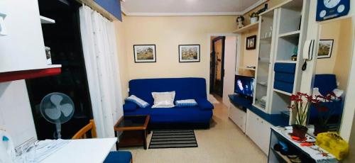 トレビエハにあるApartments atico on Calle Caballero de Rodasのリビングルーム(青いソファ、テレビ付)