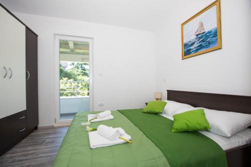 a bedroom with a green bed with towels on it at Villa Mia in Dubrovnik