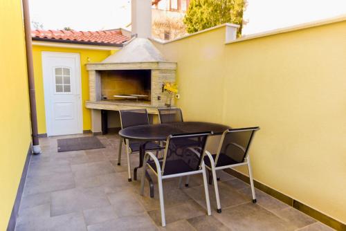 a patio with a table and chairs and a pizza oven at Apartments Bosankic in Pula