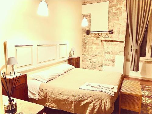 a bedroom with a bed and a stone wall at Palazzo Lupicini Affittacamere in Bisceglie