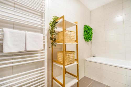 ブラショヴにあるAll Homes by Natiの棚とバスタブのあるバスルーム