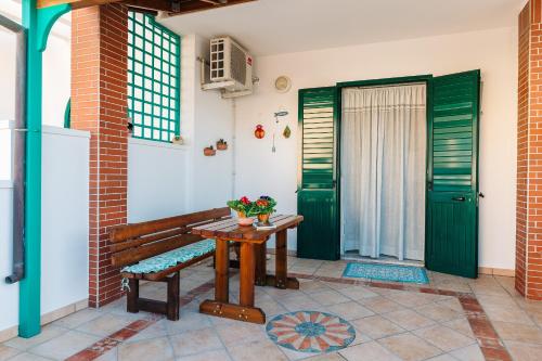una veranda con panca in legno e porte verdi di Casa vacanze Leuca a Leuca