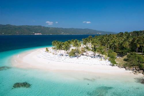 an aerial view of a beach with palm trees and water at El Pelicano Apart-Hotel in Las Galeras