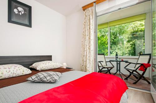 a bedroom with a red bed and a patio at Cerin Apartment in Rovinj