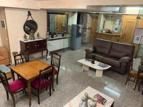 ein Wohnzimmer mit einem Sofa und einem Tisch in der Unterkunft Hostal Juan XXIII in San Sebastián de los Reyes
