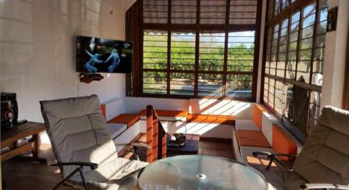 sala de estar con mesa de cristal y 2 sillas en Finca el Lunar, en Honda