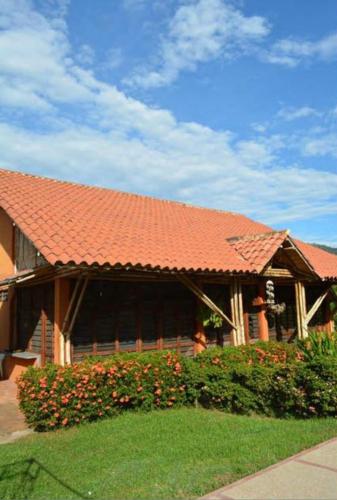 a house with an orange roof and some flowers at Finca el Lunar in Honda