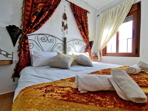 een slaapkamer met een groot bed met witte lakens en kussens bij Apartamentos Alma y Montaña in Cómpeta