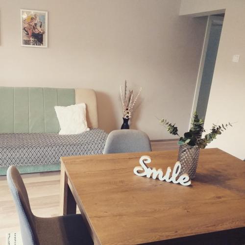 a living room with a table with a smile sign on it at Guest house Dagovic in Bajina Bašta