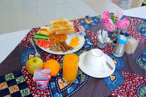 a breakfast plate of breakfast food on a table at Troy Lodge in Lusaka