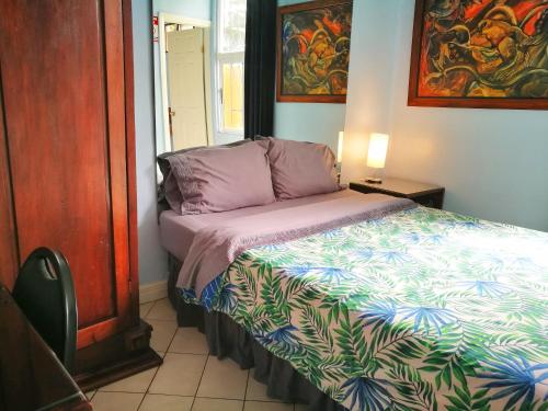 圣何塞Hotel Casa 69的小卧室配有一张带色彩缤纷的被子的床
