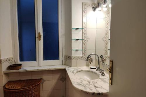 baño con lavabo y ventana en Lanza Tomasi Apartment - centre, en Roma