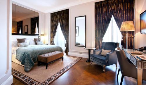 a bedroom with a bed and a desk and a chair at InterContinental Porto - Palacio das Cardosas by IHG in Porto
