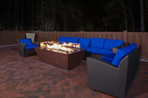 a patio with a couch and chairs and a fire pit at Holiday Inn Express & Suites Wilmington West - Medical Park by IHG in Wilmington
