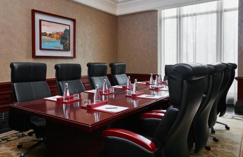 a conference room with a long table and black chairs at InterContinental Shanghai Ruijin by IHG - Downtown Historic Iconic Garden Hotel in Shanghai