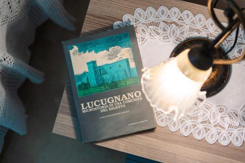a book sitting on a table next to a lamp at Iolanda Vacanze in Lucugnano