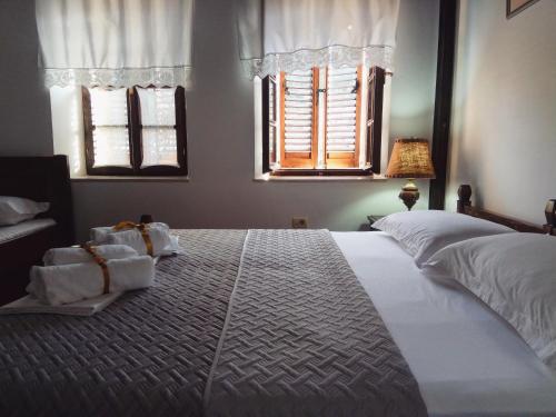 a bedroom with a large bed with towels on it at Timo's Guest House in Berat