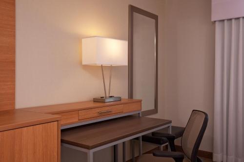 a room with a desk with a mirror and a lamp at Holiday Inn Little Rock - Presidential Downtown by IHG in Little Rock