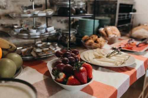 a table with plates of food and a bowl of fruit at PR Campanas de San Juan in Santiago de Compostela
