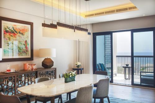 a dining room with a table and a view of the ocean at InterContinental Fujairah Resort by IHG in Al Aqah