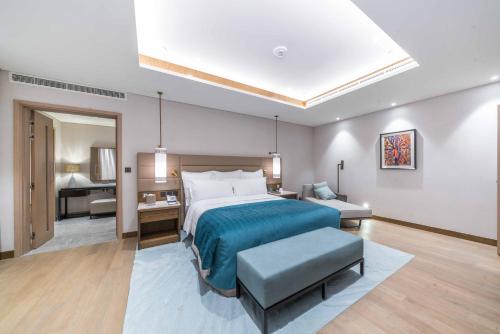 a bedroom with a large bed and a living room at InterContinental Fujairah Resort by IHG in Al Aqah
